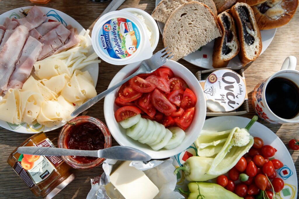 Kompulsywne (Napadowe) Objadanie Się (BED - Binge Eating Disorder) Delicious breakfast setup with cheese, cold cuts, bread, and fresh vegetables.
